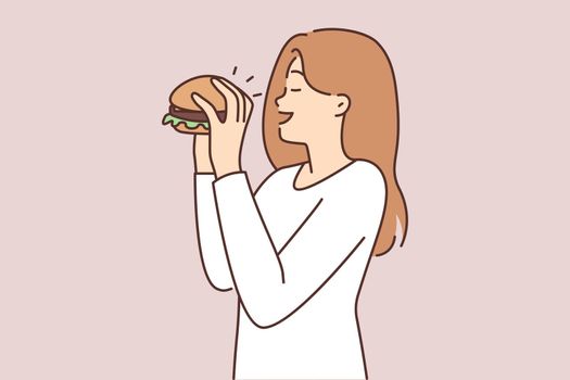 Happy woman eating hamburger