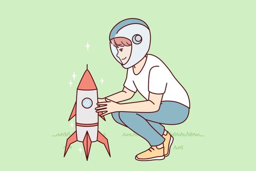Little boy near toy rocket plays as astronaut, wanting to work in space industry. Vector image