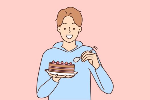 Smiling man eat cake with spoon