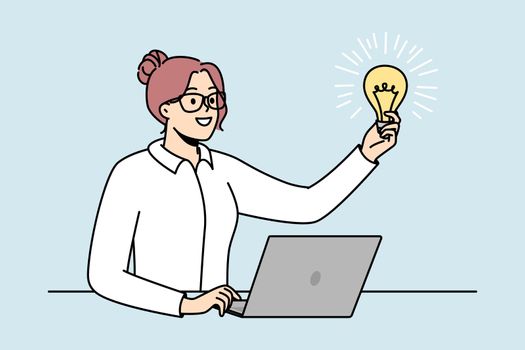 Businesswoman in glasses holds lit light bulb in front of her.