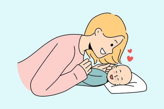 Smiling mom play with newborn baby