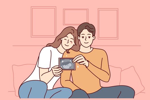 Smiling couple showing baby ultrasound