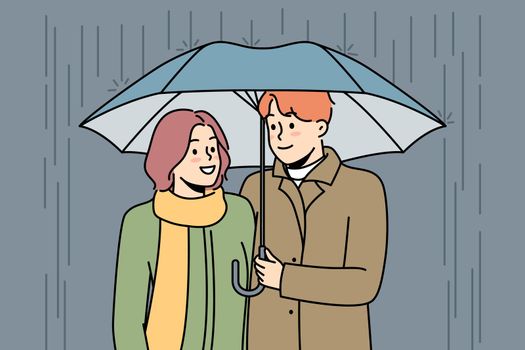 Happy couple walking in rain under umbrella