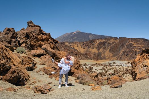 a man holds a girl in the crater of the Teide volcano.Tenerife, Canary Islands