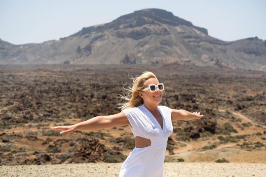 a girl in a white dress stands in the crater of the Teide volcano.Tenerife, Canary Islands