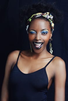 Shes a true african beauty. A beautiful african woman posing against a black background.