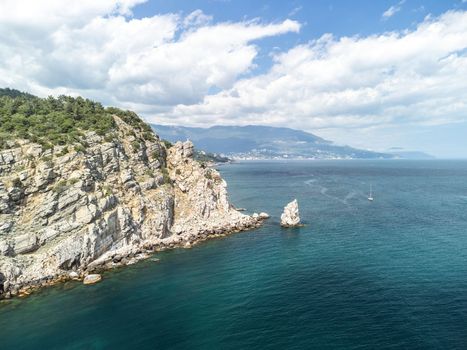 aerial photo of rock Parus Sail and Ayu-Dag Bear Mountain and near Gaspra, Yalta, Crimea at bright sunny day over the Black sea. Rock Parus in Gaspra near Swallow's nest in Crimea.