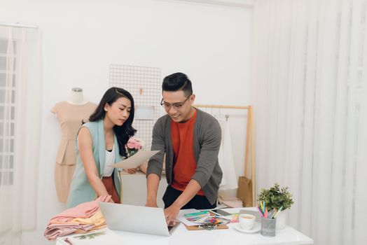 Young woman and man fashion designer using laptop to search for new ideas