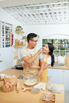 Young couple making dough in kitchen together