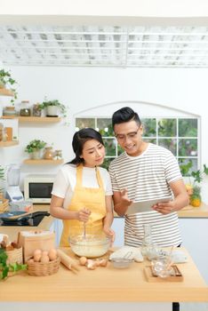 Couple in kitchen looking at recipe on internet