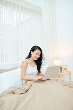 Young Lady smile and happy while write massage in email.