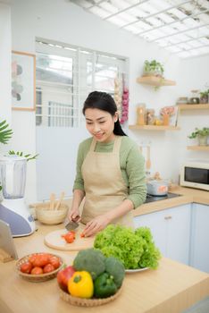 Young Asian woman at kitchen cooking breakfast