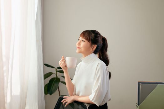 beautiful young Asian woman drinking coffee