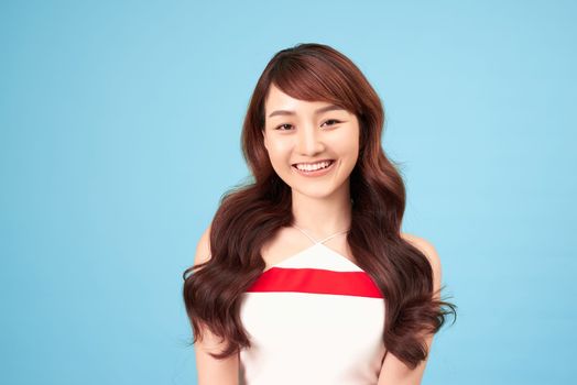 Asian woman smiling with casual clothing, blue background