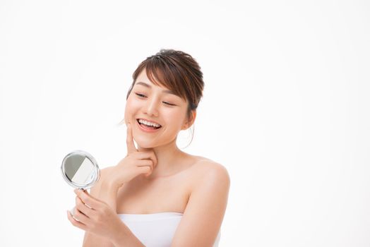 Happy young woman looking on mirror
