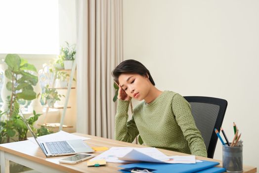 Young Asian businesswoman tired from work in the office