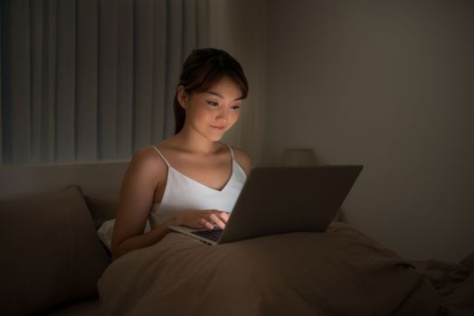 Woman looking at laptop in bed