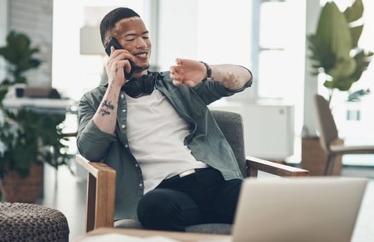 Make time for some fun. a young business man on a phone call in a modern office.