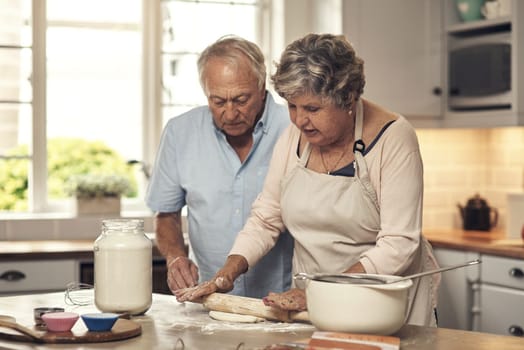 We love baking together. a senior couple baking together at home.