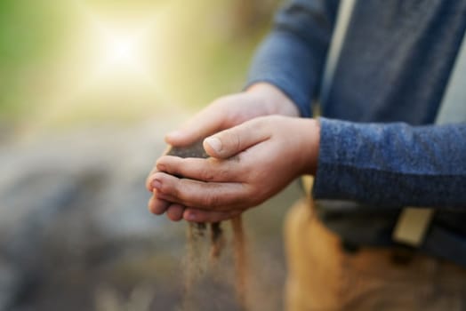 Caring for nature is caring for life. Closeup shot of a little boy holding soil in his hands.