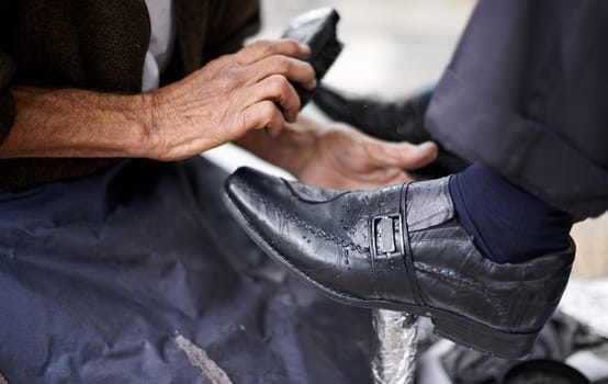 Every businessman should have shiny shoes. a shoe shiner shining a businessmans shoes.