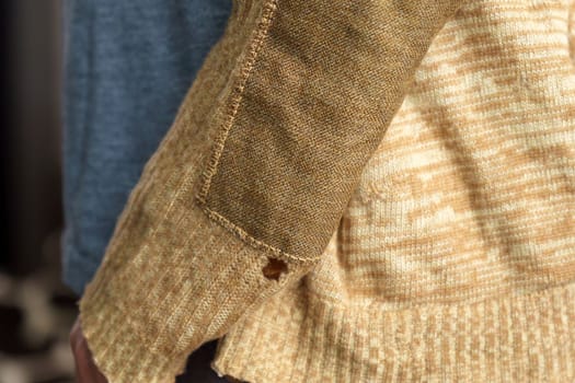 Detail of men sleeve patch fragment. Wool sweater, selective focus. Concept needlework, recycling and thrift.