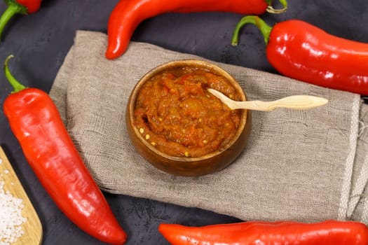 Ajvar from sweet peppers, eggplant, tomatoes, garlic and onions with spices wooden table. Balkan food. Selective focus