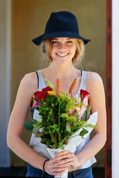 To me, flowers are happiness. A young woman holding a bunch of flowers.