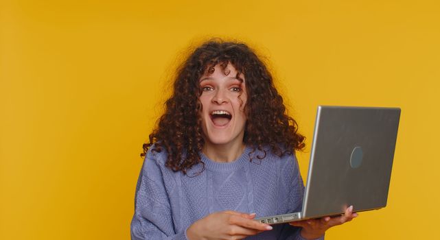 Woman use laptop scream in delight triumph winner gesture celebrate success win money in lottery