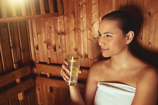 Enjoying some silence in the sauna. a young woman relaxing in the sauna at a spa.