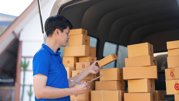 Asian courier with parcel and delivery logistic concept. Delivery man with checking list on clipboard