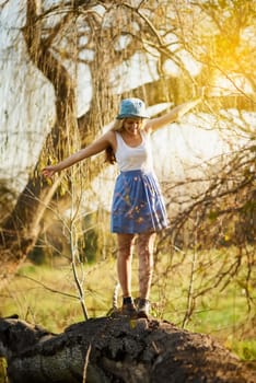The beauty of nature is all around us. a young woman on a tree stump out in the countryside.