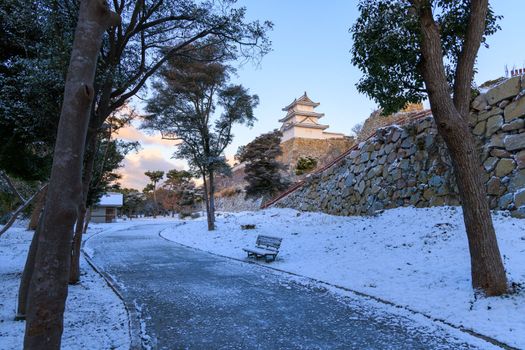 Path in snow through Akashi Castle Park on quiet winter morning