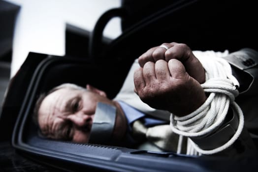 Theres no escape. A frightened businessman lying bound and gagged in the boot of his car.