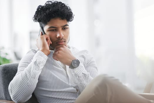 Lets brainstorm this some more. a young businessman looking thoughtful while talking on a cellphone in an office.