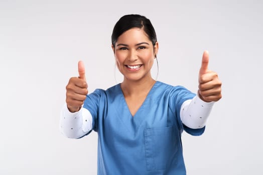 Every dive finds something new. Portrait of a young doctor showing a thumbs up sign against a white background.