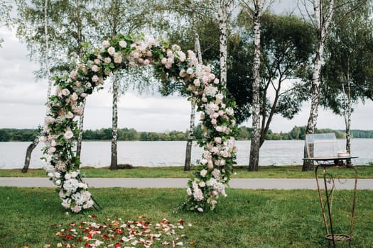 Wedding ceremony on the street on the green lawn.Decor with fresh flowers arches for the ceremony