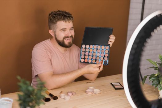 Man recording video vlog while applying cosmetics or explore cosmetic product. Guy making tutorial make-up for his blog on cosmetics.