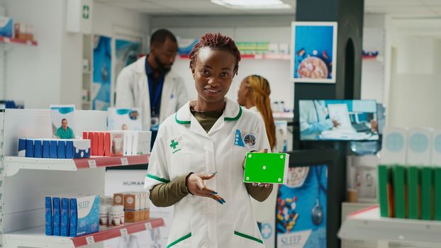 Health specialist pointing at medicine box with greenscreen