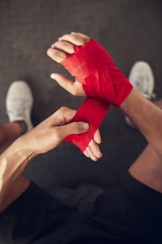 mma boxer wrapping their hand from above. Combat fighter ready for training workout. Athletic fighter prepare for boxing workout. Boxer wrapping bandage on their hand in the gym
