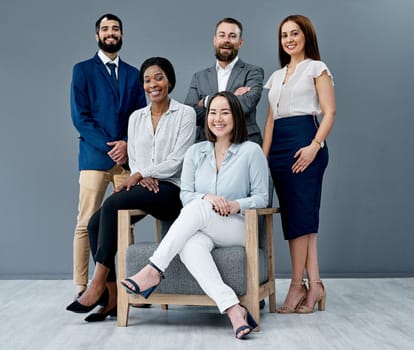 The diversity in society should be reflected in the composition of teams. Portrait of a group of businesspeople posing together against a grey background.