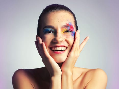 Inspiration is everywhere, even in makeup. Studio shot of an attractive young woman posing with her face brightly painted.