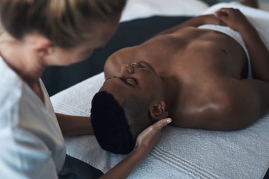 Drifting away into total relaxation. a young man getting a face massage at a spa.