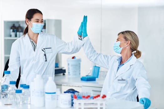Well make medical history together. two scientists giving each other a high five in a lab.