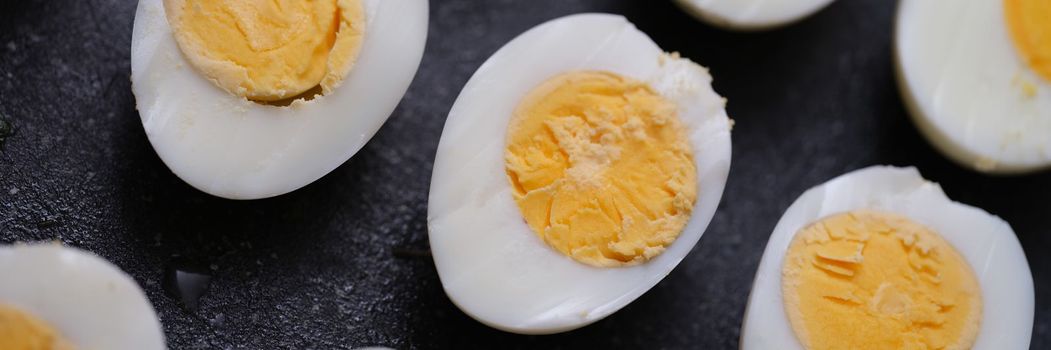 Sliced hard boiled eggs on dark background