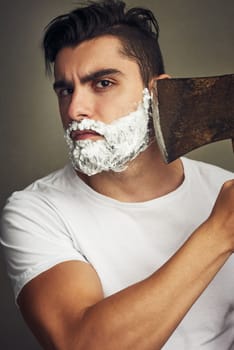 Do it in the most manly way possible. a handsome young man shaving his beard with a lumberjack.