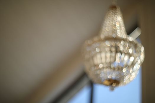 blurred crystal chandelier bokeh out of focus. Glamour background with copy space.