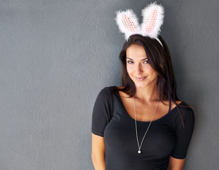 This little bunny is going to have some fun. Portrait of a gorgeous brunette wearing bunny ears.