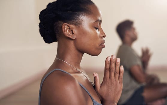 Quiet the mind and the soul will speak. an attractive young woman meditating in a yoga class.
