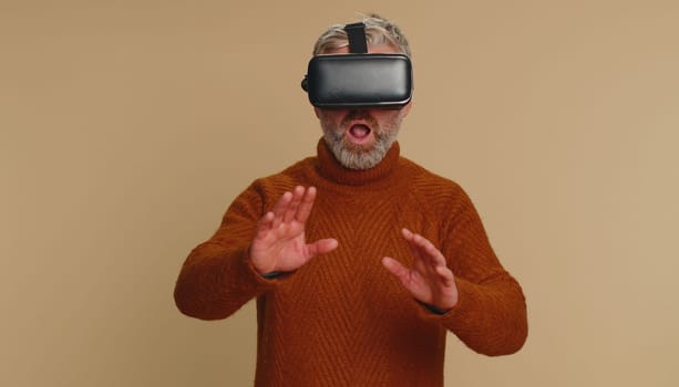 Senior man using virtual reality headset helmet to play simulation game app, watching video content